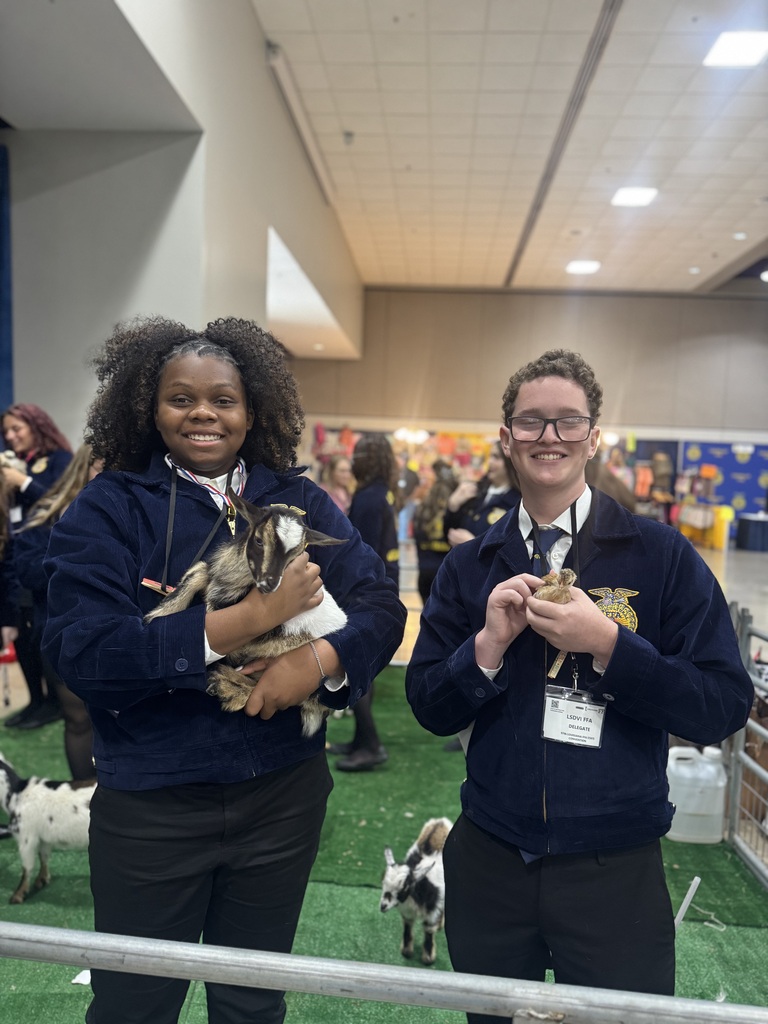 Students smiling and holding baby goats and ducklings