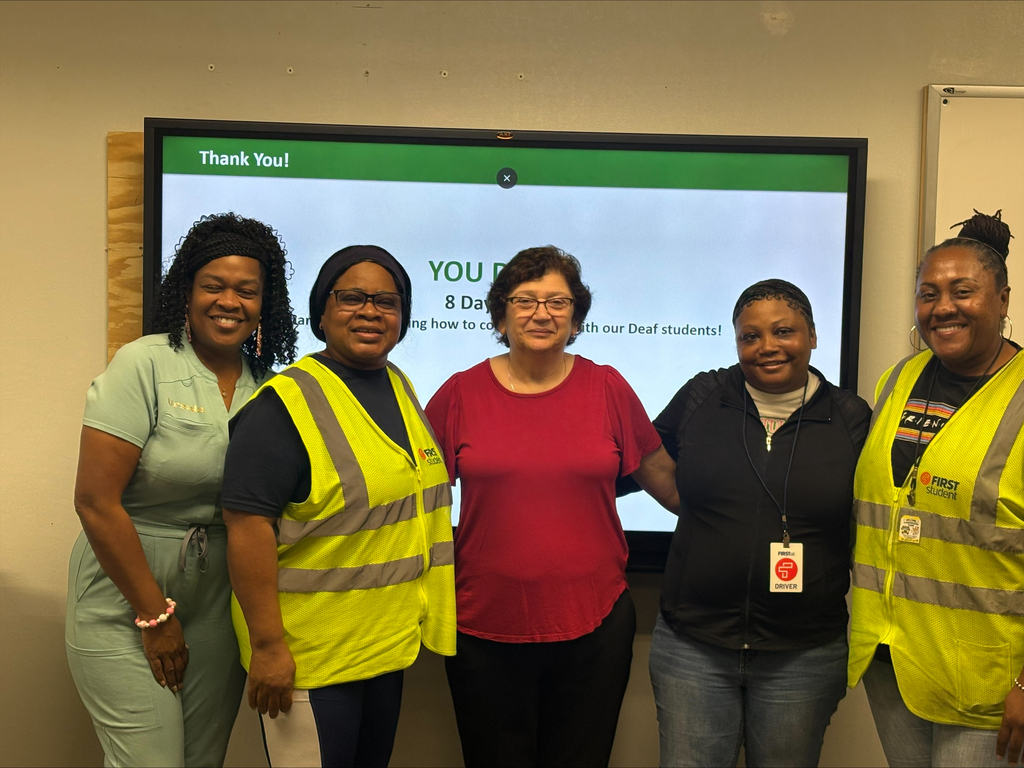 A group of people smiling in bus vests