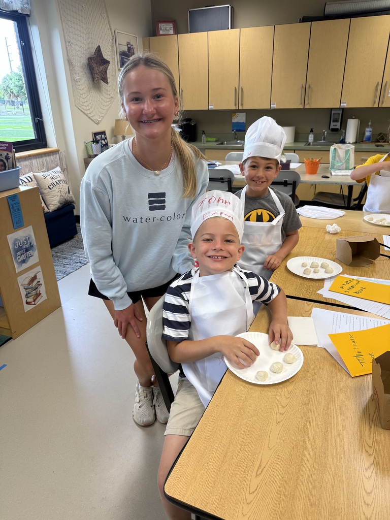 Girl counselor helping little boys with cooking activity