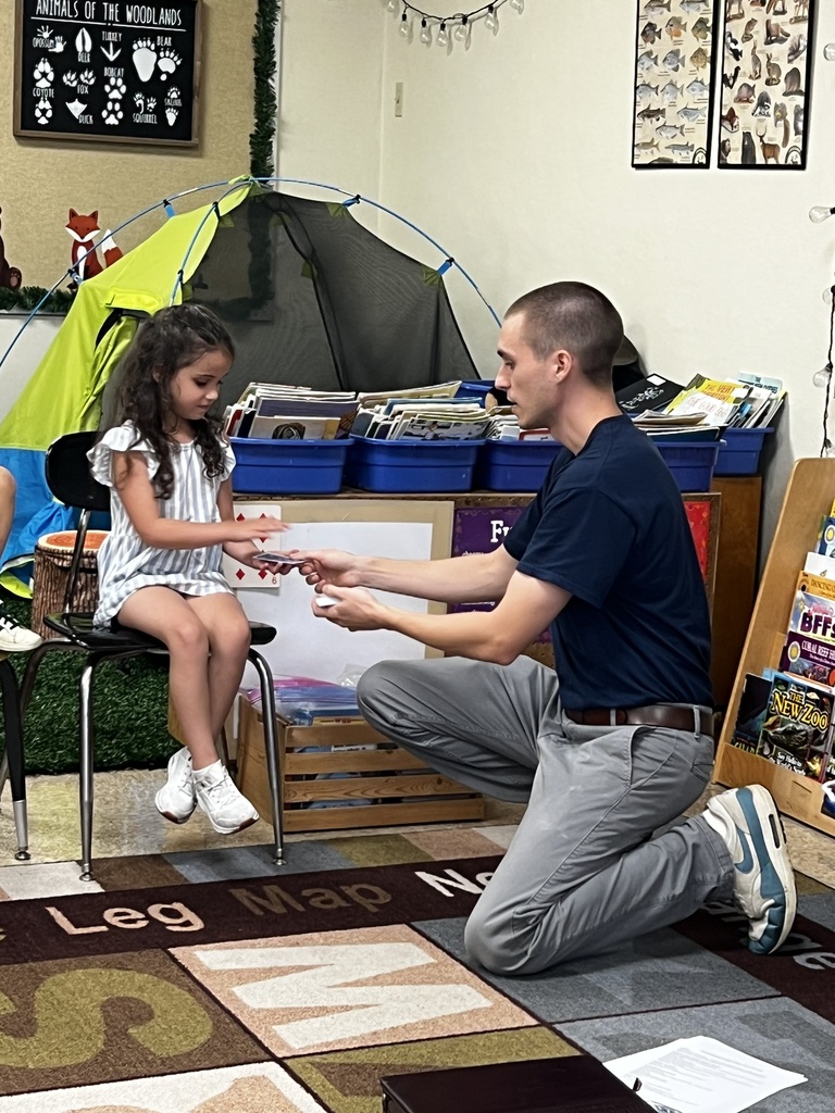 Adult magician teaching little girl a magic trick