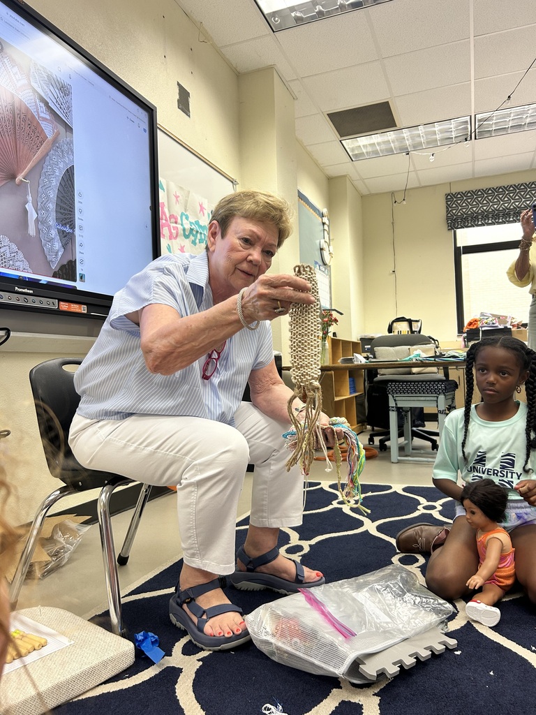 Textile professor visiting American girl doll camp with student seated