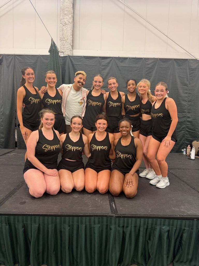 Girl dancers posed with male coach wearing black tanks with "U" Spirit Steppers displayed