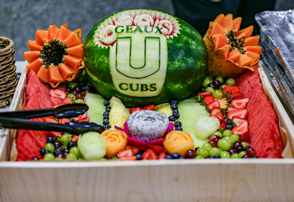 Carved watermelon display with “Geaux Cubs” and ULS-themed fruit decorations.