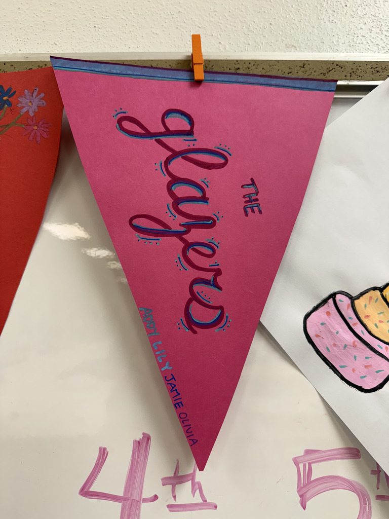 A pink paper pennant hanging on a wall with stylized purple and blue cursive text that reads "The Glazers."