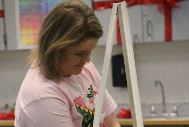 While teaching her basic art class, miss Oliver is shown teaching how to use a easel for their future projects.