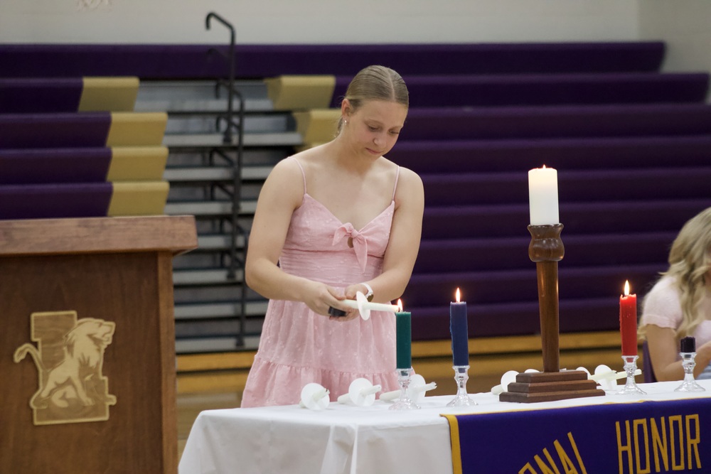 BRIGHTEN UP. During the NHS cermony Seinor Emery Stholmann takes her turn at lighting one of the five candles. Stholmann then missied the wick causing her to just walk to the stand and speak. (Senior Lincon Hines helped her out after)