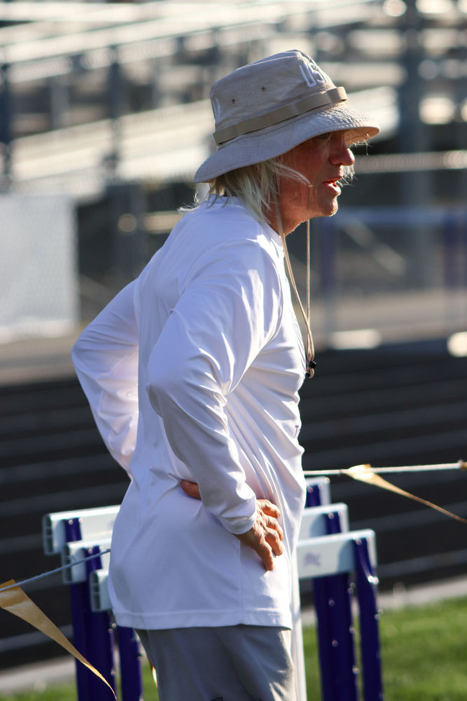 HELPING HAND. At the Louisville track meet on April 24th, Coach Dave stood nearby the hurdles after freshman Jillian Harvey competed in the 300m hurdles.