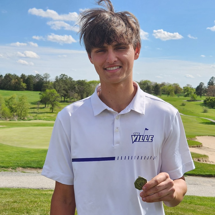 A member of the Louisville boys golf team holding a first place medal