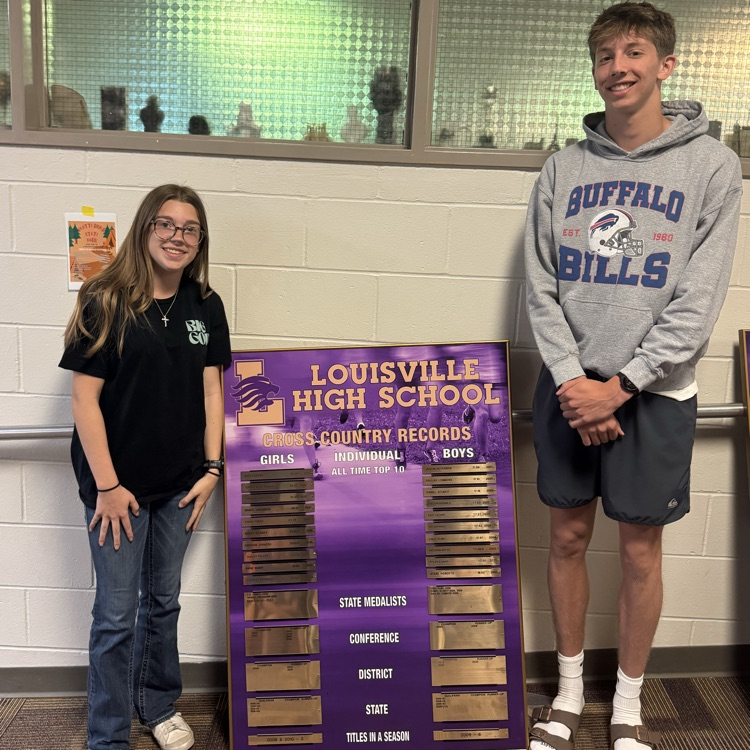 student standing by a record board