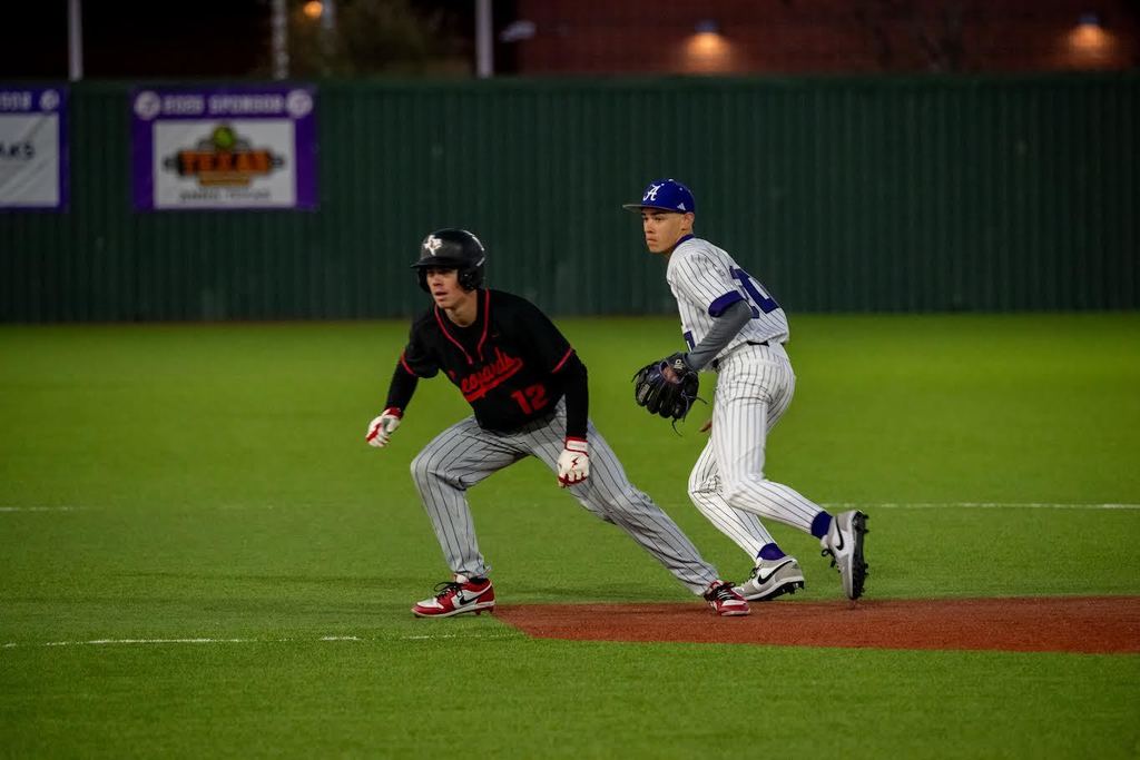 Two baseball players in action, one bending to catch a ball, the other running towards the base.
