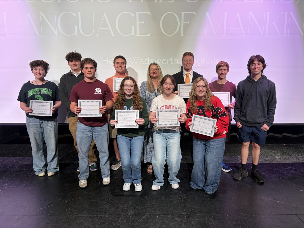 A group of people on a stage holding certificates. A screen behind them displays "Language of Making".