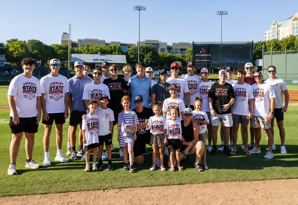 Group of people wearing white shirts with text and numbers pose on a baseball field.