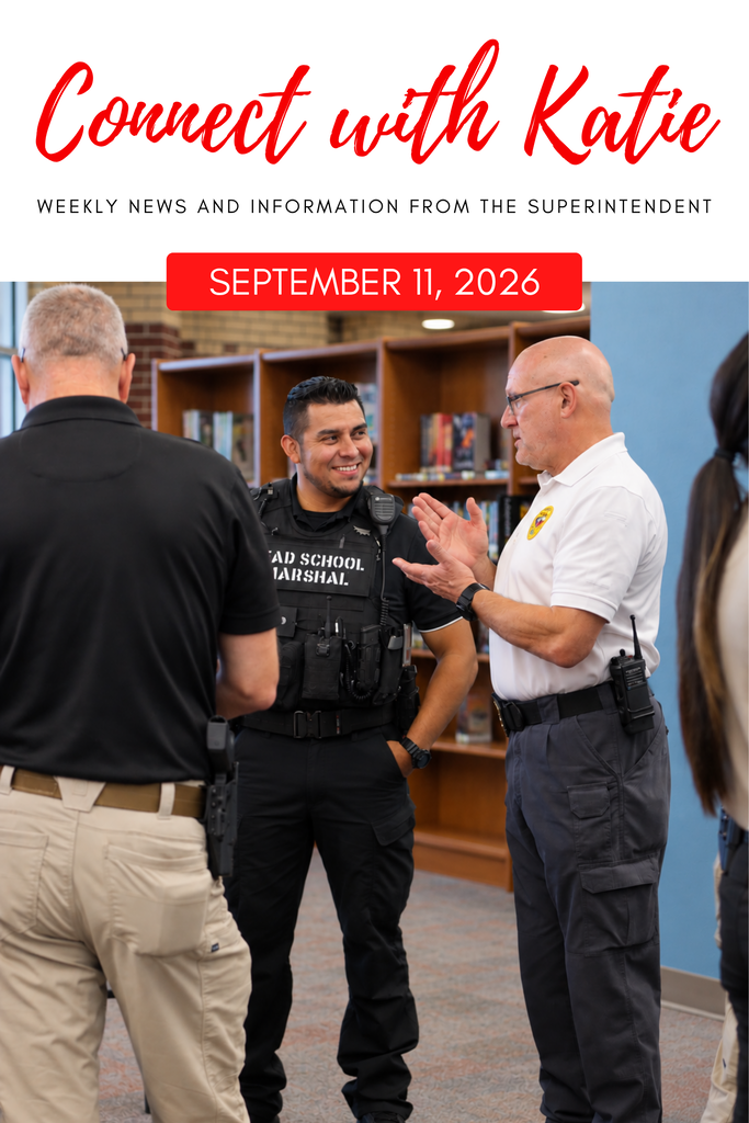 Three men stand in a library, engaged in conversation. The middle man wears a school marshal uniform and a watch.