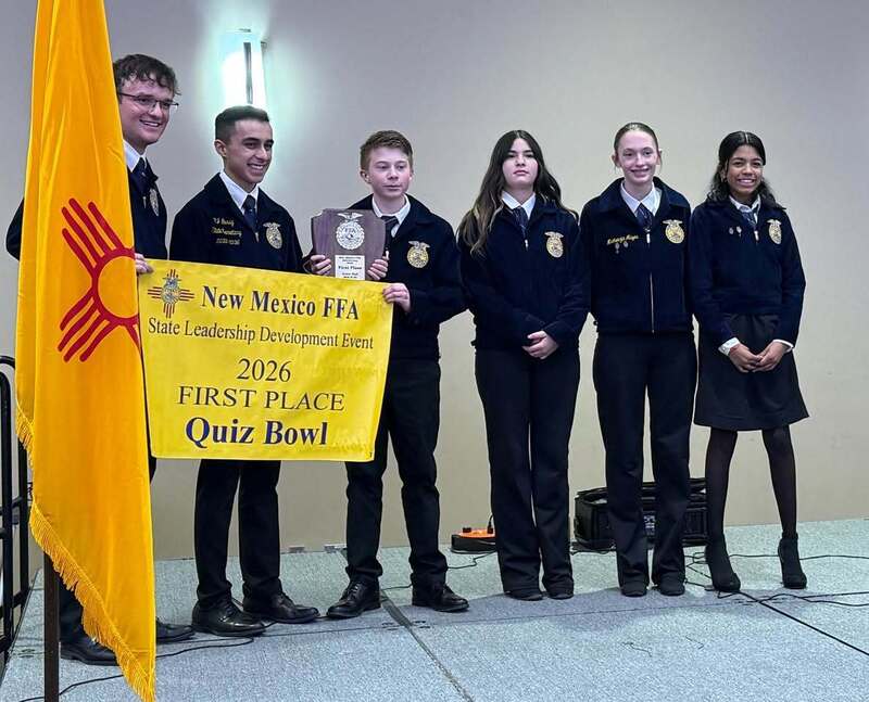 students pose with 1st place quiz bowl banner