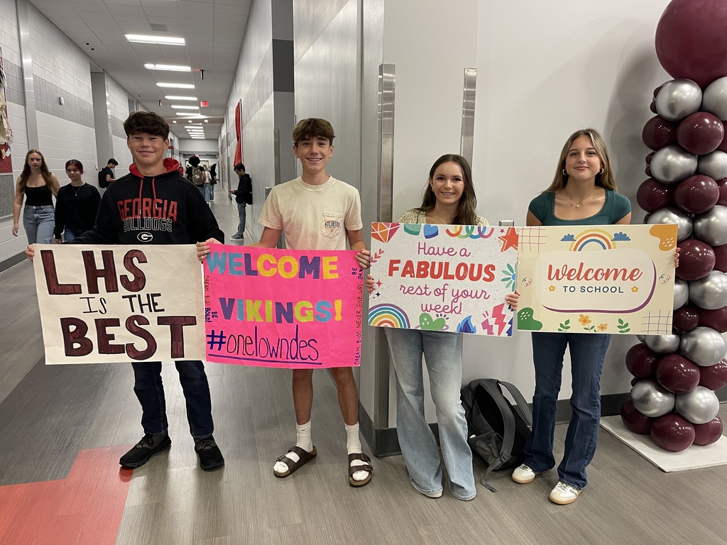 Students holding Welcome Wednesday signs