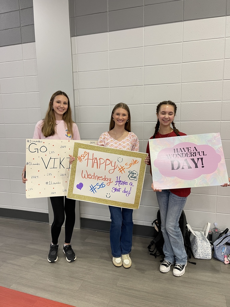 Students with Welcome Wednesday signs