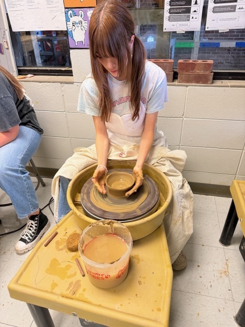 Student using the potter's wheel 