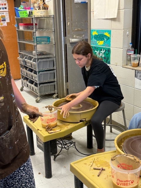 Student using the potter's wheel 