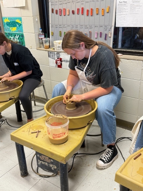 Student using the potter's wheel 