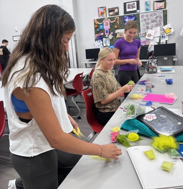 Students making felt from wool fibers