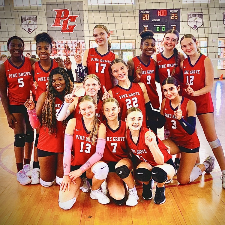volleyball team posing after winning