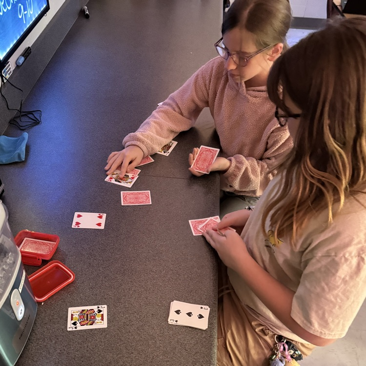 students playing card game to review math skills