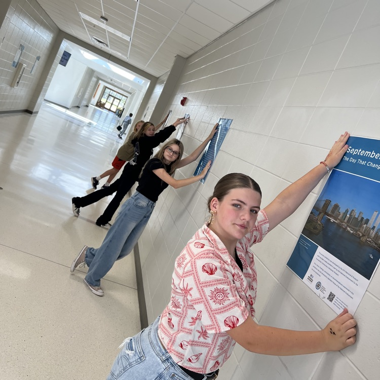 students hanging poster exhibit