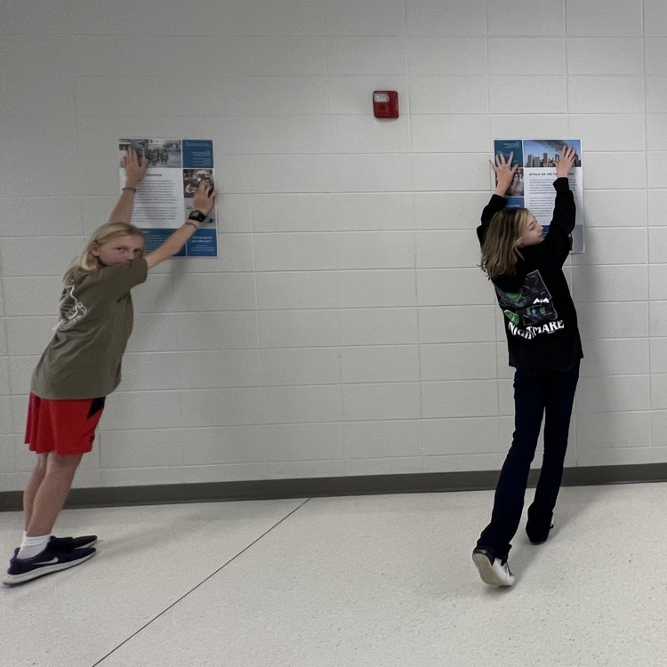 students hanging poster exhibit