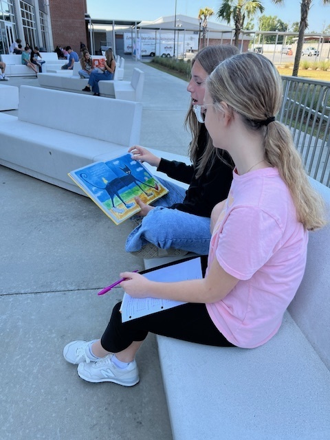 Student practicing reading aloud to other students.