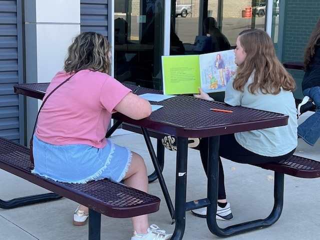 Student practicing reading aloud to other students.