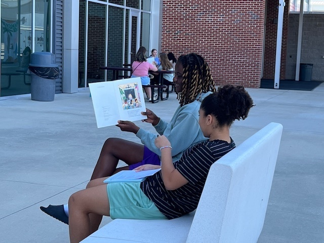 Student practicing reading aloud to other students.