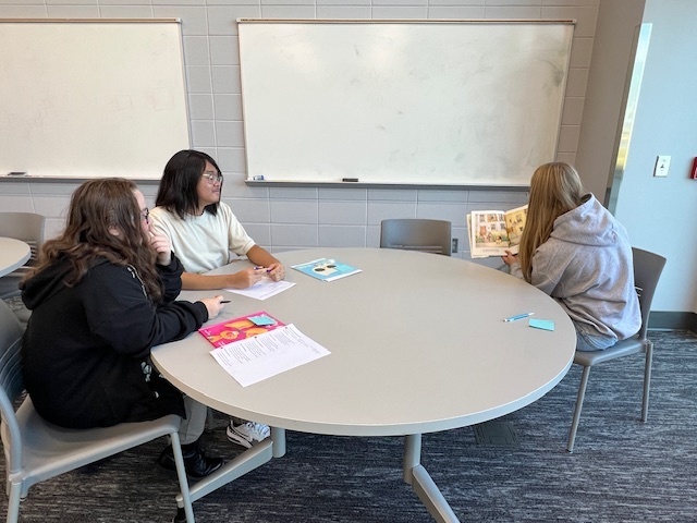 Student practicing reading aloud to other students.
