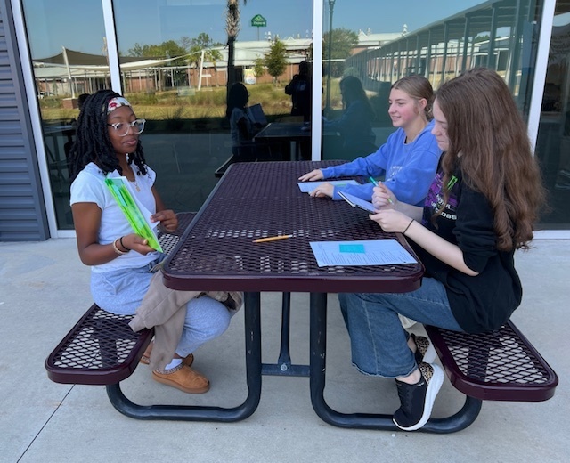 Student practicing reading aloud to other students.
