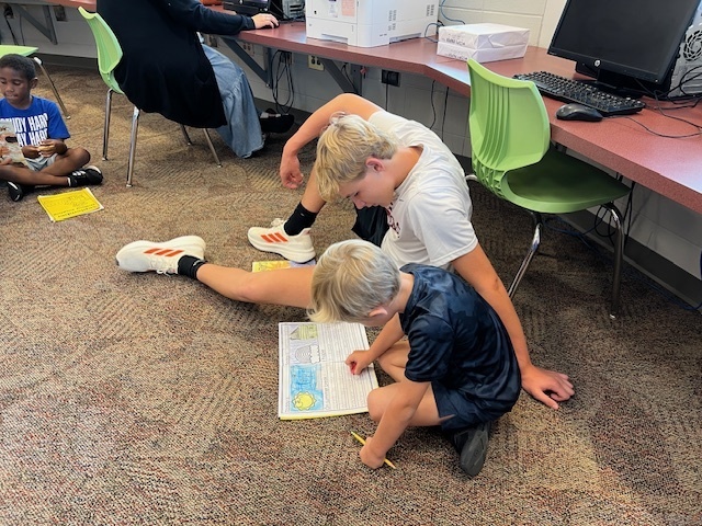 LHS Lit 1 students reading to WES 1st grade students