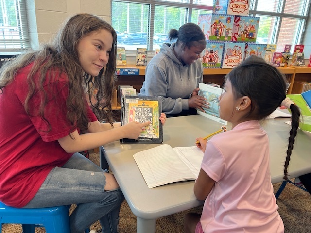 LHS Lit 1 students reading to WES 1st grade students