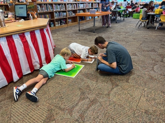 LHS Lit 1 students reading to WES 1st grade students