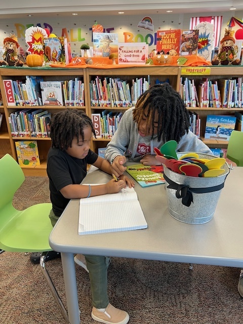 LHS Lit 1 students reading to WES 1st grade students