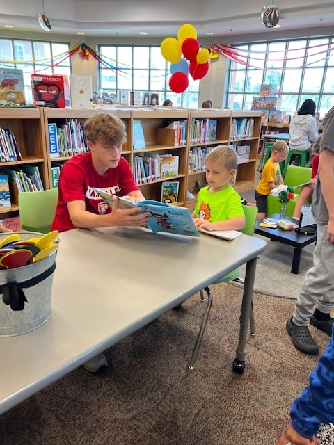 LHS Lit 1 students reading to WES 1st grade students