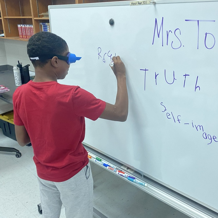 student doing activity wearing upside down goggles 