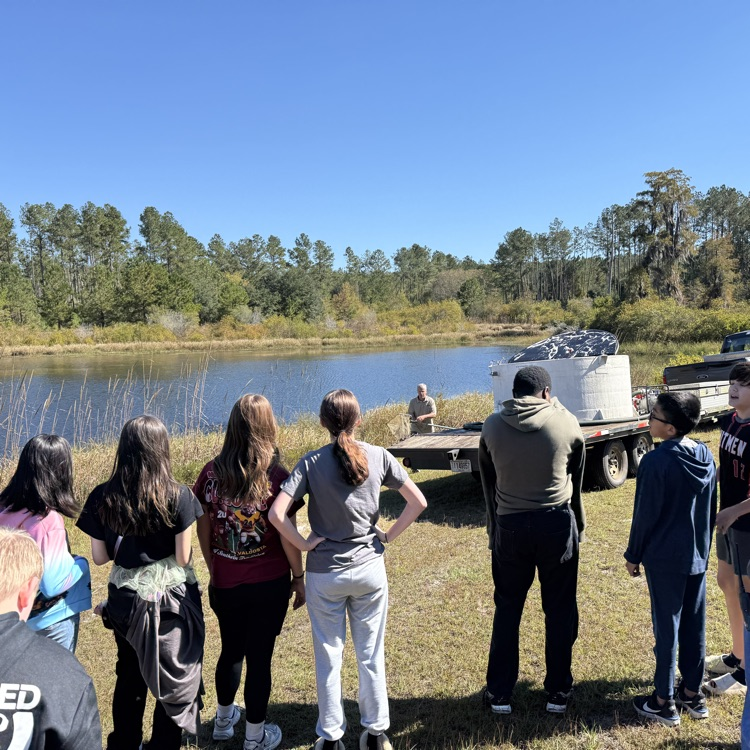 students watching carp being added 