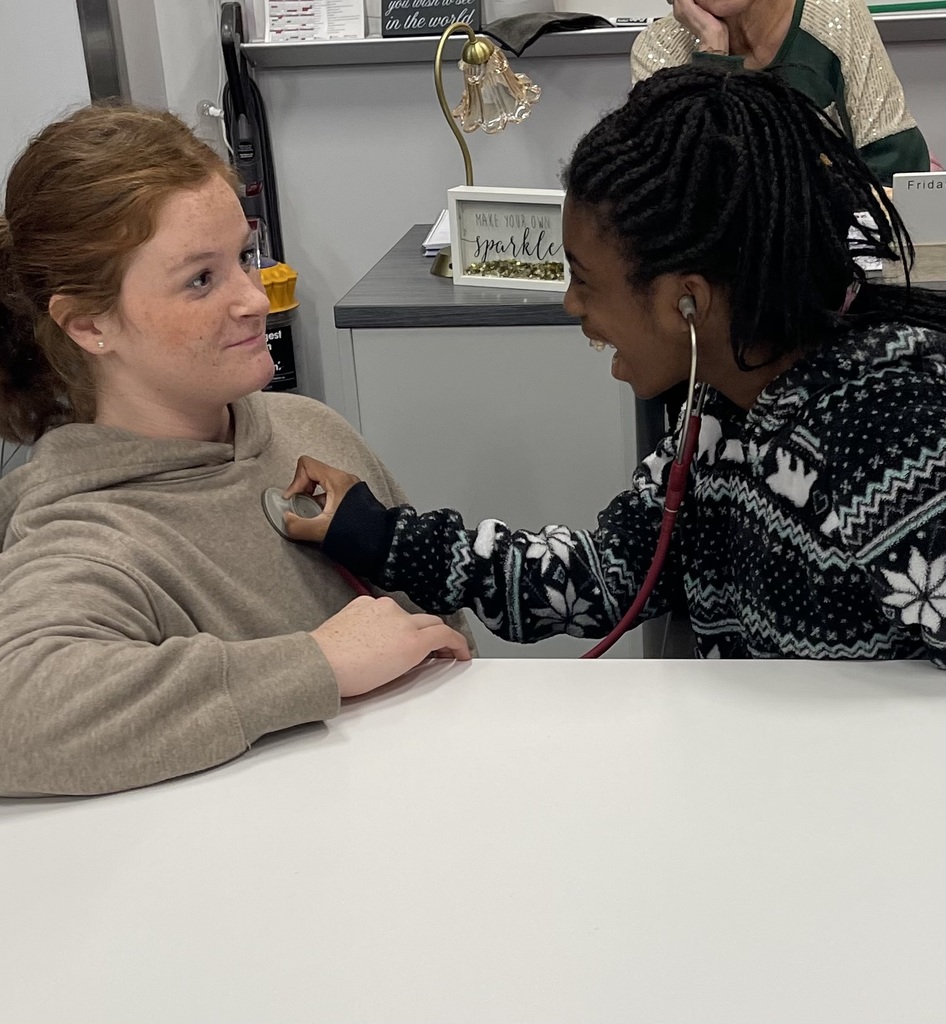Student listening to another student's heart with a stethoscope