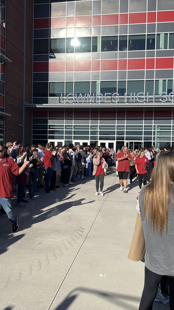 Athletic trainer and Cheer coach leading the cheerleaders through supporters to bus