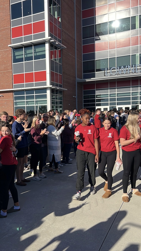 Cheerleaders walking through supporters to the bus