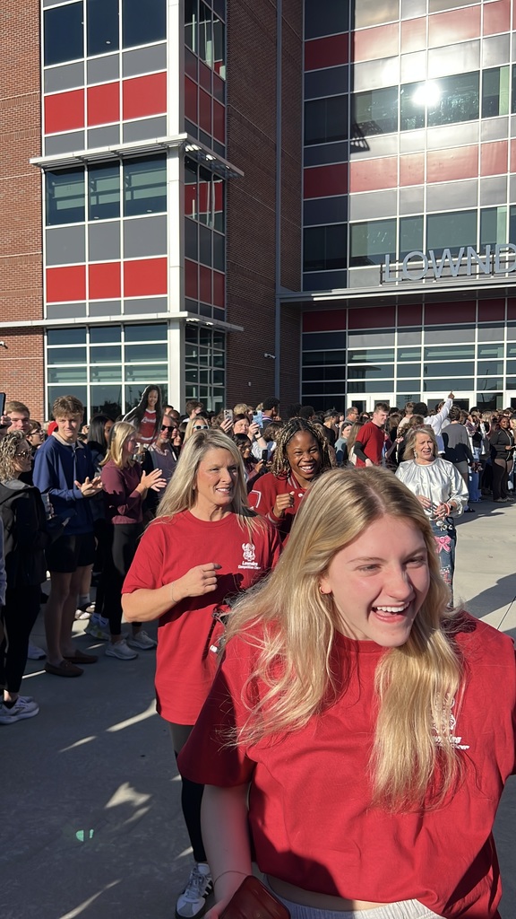 Cheerleaders walking through supporters to the bus