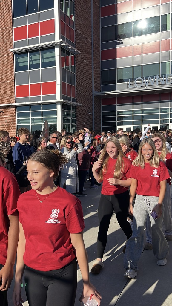 Cheerleaders walking through supporters to the bus