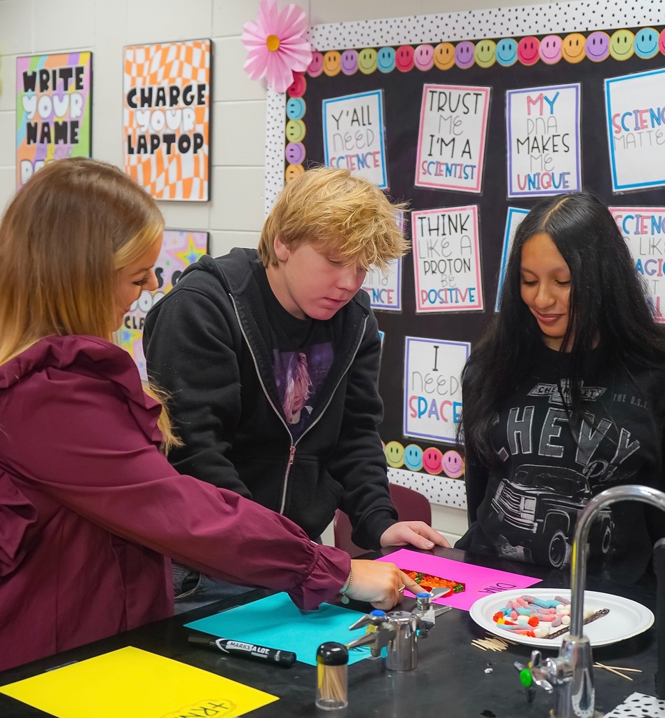 Teacher looking at students' model