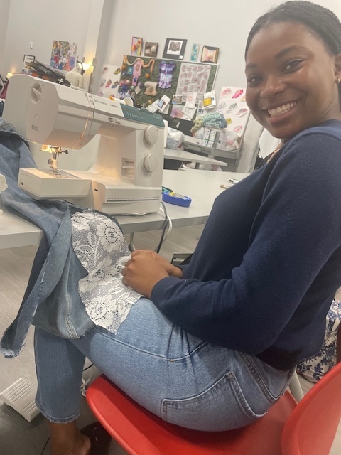 Student sewing lace into a denim split