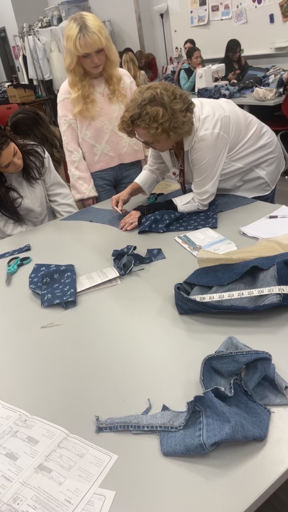 Teacher demonstrating how to use a sewing tool