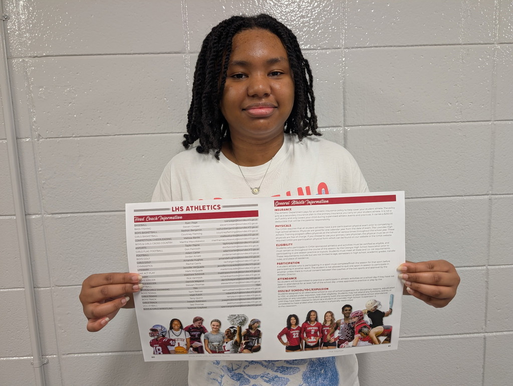 Student with layout for Athletics page of the Viking Voyage