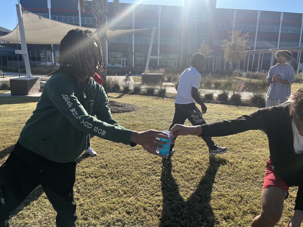 Students playing a relay game with cups